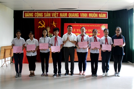 Ông Nguyễn Văn Minh - Bí thư Đảng ủy, Chủ tịch HĐND trao thưởng cho học sinh