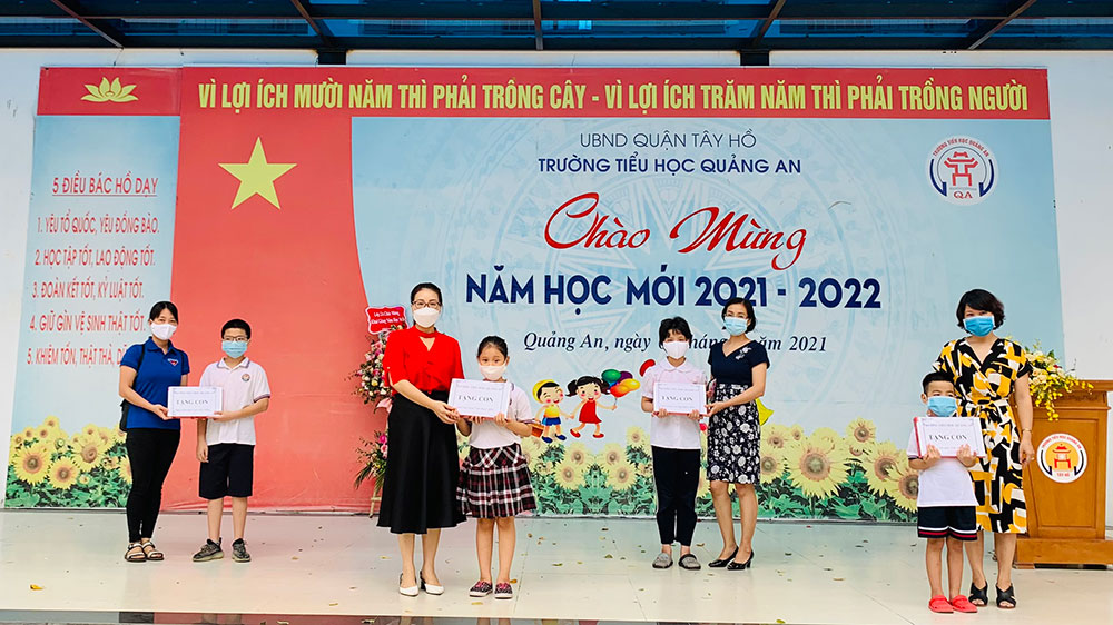 Cô Phi Thị Thanh Hương; Hiểu trưởng trường TH Quảng An trao máy tính cho học sinh có hoàn cảnh khó khăn.