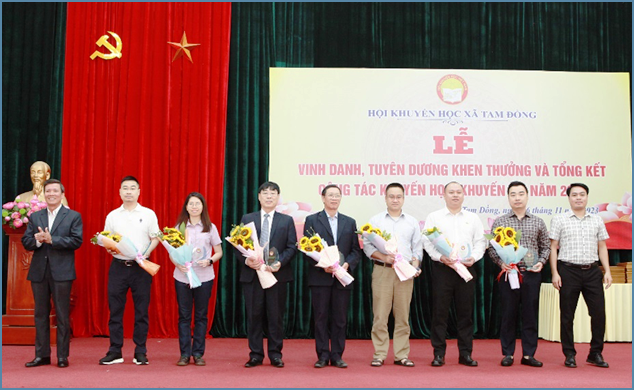 Ông Ngô Quang Minh- HUV, Bí thư Đảng ủy xã, ông Bùi Văn Công - Chủ tịch Hội khuyến học huyện Trao kỷ niệm chương và tặng hoa cho các tiến sĩ